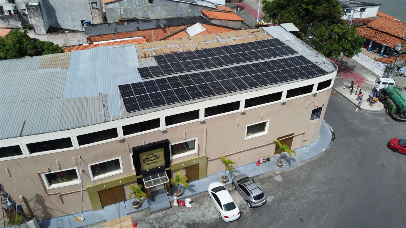 Prédio comercial com duas fileiras longas de módulos solares no telhado